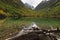 Turquoise Baduk lake in mountains in Dombay national park, Caucasus, Russia. Beautiful autumn landscape with reflections in clear