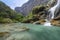 Turquoise blue pool under tropical waterfall