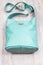 Turquoise colour leather handbag on wooden table