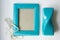 Turquoise decorative photo frame, vase and pearl beads on a white background.