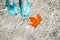Turquoise flip flops underwater and orange torn maple leaf. Clear water. Autumn at sea, Croatia