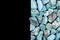 Turquoise heap stones texture on half black background. Place for text