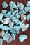 Turquoise heap up stones texture on brown varnished wood background