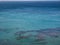 Turquoise ionian seascape with skyline and underwear rocks. Waving water texture background with copy space