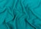 Turquoise jersey fabric matte texture top view. Blue knitwear background. Fashion color trendy clothes. Website backdrop