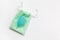 Turquoise menstrual cup on green small bag on white background. Concept zero waste, savings, minimalism, these days. Feminine