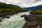 Turquoise mountain rapid river flows between the mountains