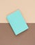 Turquoise notepad on brown background. Working place. Space for notes. Top view.