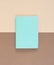 Turquoise notepad on brown background. Working place. Space for notes. Top view.