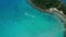 Turquoise ocean water and boats cruising near coastline of tropical island.