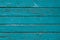 Turquoise painted fence, dilapidated cracked boards, green wooden fence. Rustic timber texture. Weathered oak planks. Natural back
