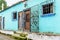 Turquoise painted house exterior with decorated wrought iron bar