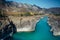 Turquoise river in deep rocky gorge surrounded by high mountains under blue sky on sunny autumn day. Amazing natural landscapes