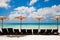 Turquoise sea, deckchairs, white sand and beach umbrellas.