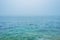 Turquoise sea ocean water horizon during fog mist storm for background texture