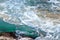 Turquoise sea water hits stony shore. Natural background.