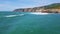 Turquoise sea water rolling to rocky shore. Aerial view waves washing coastline.