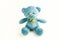 Turquoise soft teddy bear with checkered scarf and embroidered heart on the chest on a white background. Children`s toy. Love, a
