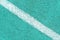 Turquoise synthetic surface of a track of athletics stadium with white diagonal line