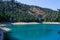 Turquoise water of the lake, pine forest and mountains. Stunning background with nature