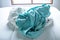 Turquoise and White crumpled bed sheet on white bed, Selective focus, Bedroom cleaning concept