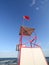 turret of lifeguard on the beach with the red flag