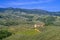 Tuscan countryside with vineyards, olive trees, woods, farms and town