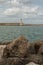 Tuscany Coastline: White Lighthouse Tower, Cliffs and Stone Jetty near Sea, Italy