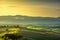 Tuscany countryside misty panorama, rolling hills and green fields on sunset. Pisa, Italy