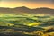 Tuscany countryside misty panorama, rolling hills and green fields on sunset. Pisa, Italy