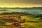 Tuscany countryside misty panorama, rolling hills and green fields on sunset. Pisa, Italy