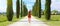 Tuscany Holidays. Panoramic banner view of young beautiful woman walking in typical road in Tuscany. Travel landscape of Italy