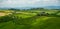 Tuscany landscape with green rolling hills in spring time ,agriculture crop  and farming house