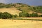 Tuscany landscape with hills, yellow fields and hay bales, Tuscany, Italy.