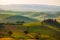 Tuscany landscape at sunrise. Typical for the region tuscan farm house, hills, vineyard. Italy