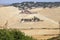 Tuscany rural landscape with yellow fields and countryside farm, Italy.