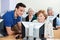 Tutor Assisting Senior Woman During Computer Class