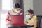 The tutor at home in a medical mask explains to the girl the course of solving homework