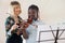 Tutor Teaching High School Student To Play Violin In Music Lesson