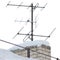 TV and communication aerials on snowy roof of residential house, multiple isolated dvb-t antennas winter scene, large detailed