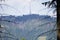 TV-radio tower on top of the mountain. Antenna behind the mountain panoramic view. Smog and fog in the forest