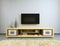 TV unit in living room with yellow TV on the wall.