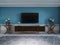 TV unit, TV set in a modern living room in a classic style with blue walls, black TV cabinet, console table with interior decor