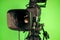 TV video camera on the background of a green chroma key. Camcorder lens