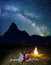 Twain lovers admiring incredibly beautiful starry sky and Milky way and lying near the bonfire at night