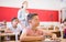 Tween boy listening to schoolteacher and writing in notebook in class