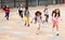 Tween boys and girls with school backpacks running in schoolyard