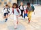 Tween boys and girls with school backpacks running in schoolyard