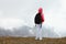 Tween girl with backpack looking on beautiful mountains in clouds, family travel concept