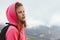 Tween girl with backpack looking on beautiful mountains in clouds, family travel concept